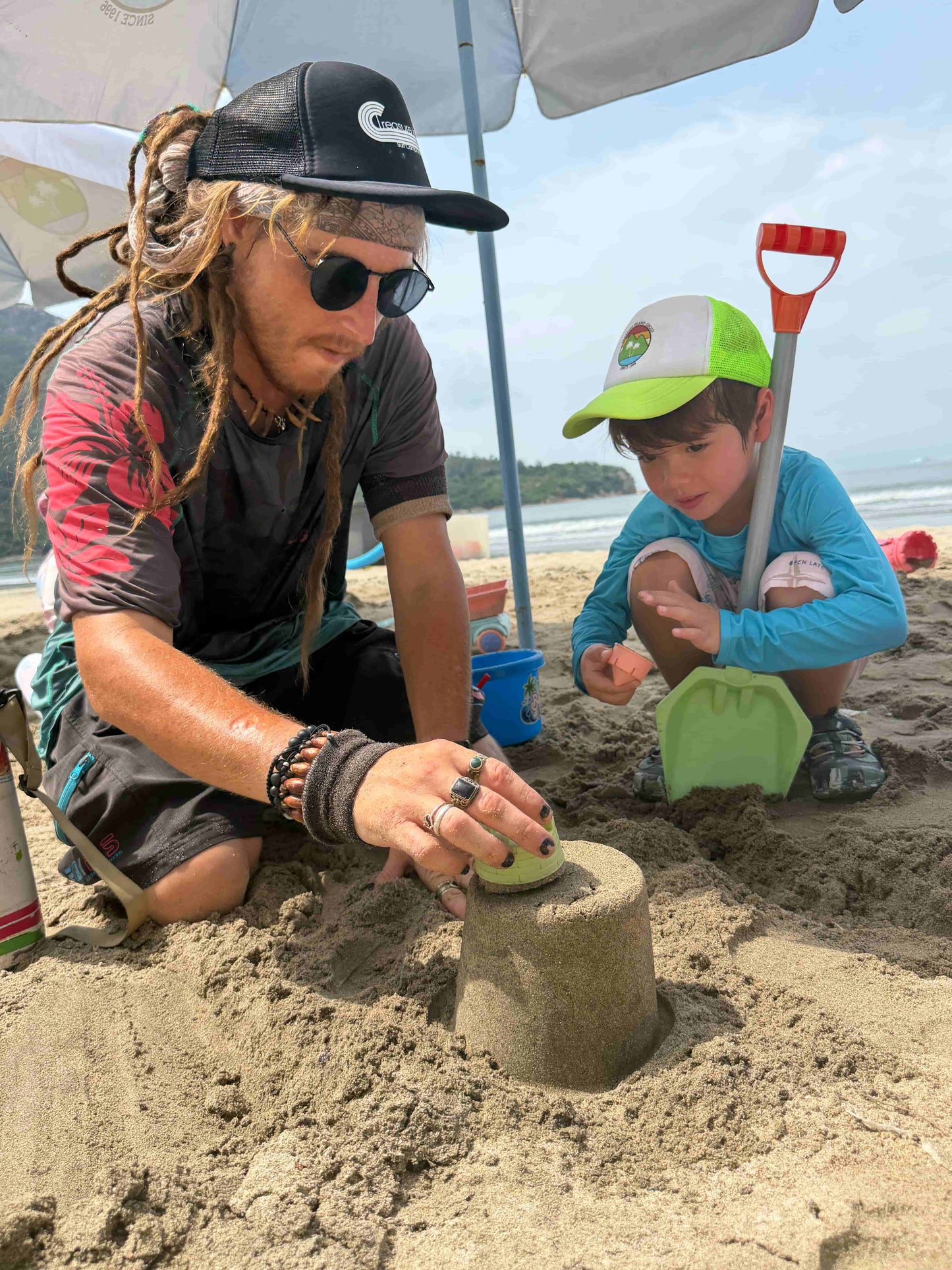 Man and child building sandcastles on a beach